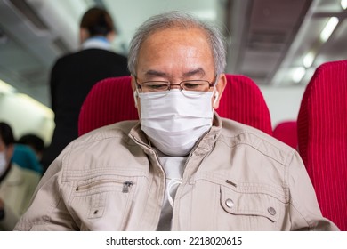 Asian senior man wearing protective mask using smartphone search the internet or watching movie at airplane seat. travel on vacation during Coronavirus epidemic. new normal lifestyle - Powered by Shutterstock