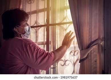 Asian Senior Mature Woman With Mask Medical Lockdown At Home.quarantine During COVID19 Coronavirus.social Distancing.Mental Health.Depressed Mind Thinking.Senior Asian Woman At Home.patient Stress.