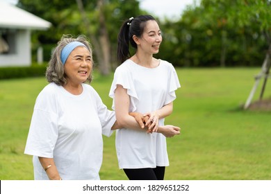 Asian Senior Mother And Adult Daughter Holding Hands And Exercise Walking Outdoor At  Park. 