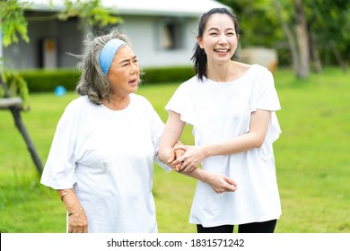 Asian Senior Mother And Adult Daughter Holding Hands And Exercise Walking Outdoor At  Park. 