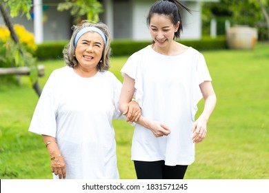 Asian Senior Mother And Adult Daughter Holding Hands And Exercise Walking Outdoor At  Park. 