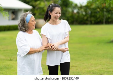 Asian Senior Mother And Adult Daughter Holding Hands And Exercise Walking Outdoor At  Park. 