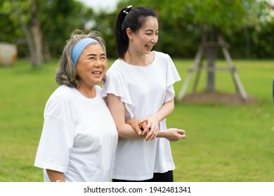 Asian Senior Mother And Adult Daughter Holding Hands And Exercise Walking Outdoor At  Park. 