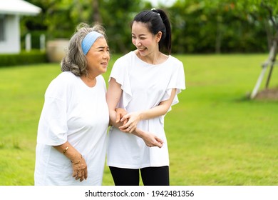 Asian Senior Mother And Adult Daughter Holding Hands And Exercise Walking Outdoor At  Park. 