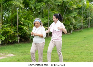 Asian Senior Mother And Adult Daughter Holding Hands And Exercise Walking Outdoor At  Park. 