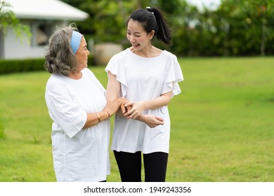 Asian Senior Mother And Adult Daughter Holding Hands And Exercise Walking Outdoor At  Park. 