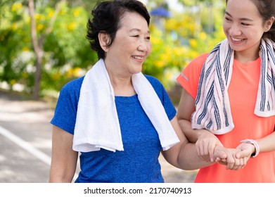 Asian Senior Mother And Teenager Daughter Holding Hands With Exercise Walking At Park