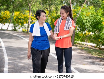 Asian Senior Mother And Teenager Daughter Holding Hands With Exercise Walking At Park