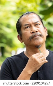 Asian Senior Old Man Thinking Or Planning For Something In Green Nature Park