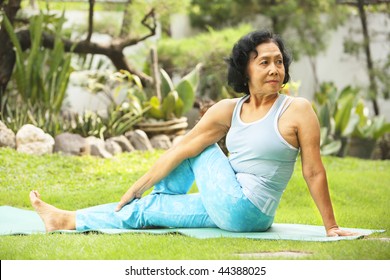 Asian Senior Old Woman Practicing Yoga At Garden