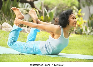 Asian Senior Old Woman Practicing Yoga At Garden