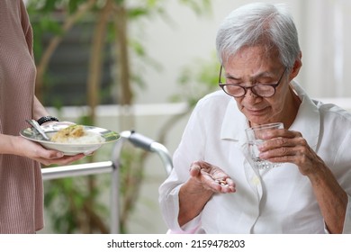 Asian Senior Patient Taking Medication,drugs Pills And Capsules Before Meal,treatment Of Disease,old Elderly People Taking Medicine And Eating Food At Home,medical Treatment And Health Care Concept