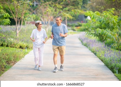 Asian Senior Retired Couple Jogging Or Exercise In The Park. Healthy Elderly People Concept