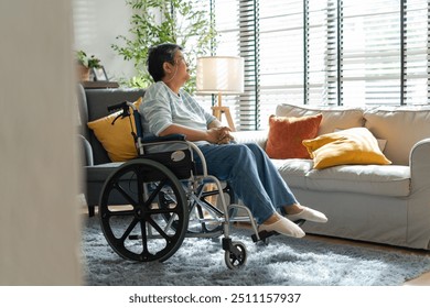 asian senior retired woman sitting on wheel chair in living room at home.Sad or depressed Elderly female in a wheelchair looking through window,asian senior retired woman alone at home,after retirment - Powered by Shutterstock