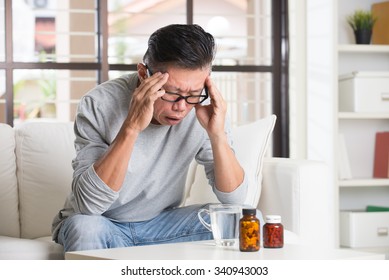 Asian Senior With Severe Headache And Medicine