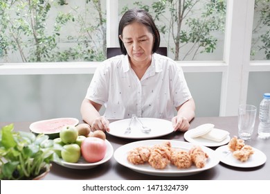 Asian Senior woman bored with food because indigestion