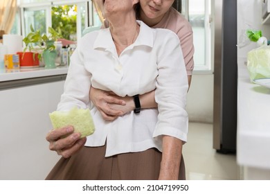 Asian senior woman with bread stuck in her throat,caregiver helping elderly people suffering from choking or food obstruction in the trachea in causing suffocation,emergency first aid,life saving