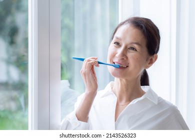 Asian Senior Woman Brushing Her Teeth