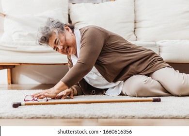 Asian Senior Woman Falling Down Lying On Floor At Home Alone. Elderly Woman Pain And Hurt From Osteoporosis Sickness Or Heart Attack. Old Adult Life Insurance With Hearlth Care And Treatment Concept