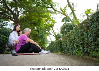 Asian Senior Woman Fell Down On Lying Floor Because Faint And Limb Weakness And Pain From Accident And Woman Came To Help Support And Call Emergency. Concept Of Old Elderly Insurance And Health Care