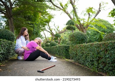 Asian Senior Woman Fell Down On Lying Floor Because Faint And Limb Weakness And Pain From Accident And Woman Came To Help Support And Call Emergency. Concept Of Old Elderly Insurance And Health Care