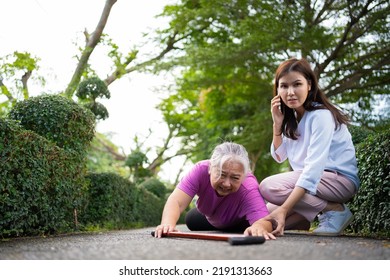 Asian Senior Woman Fell Down On Lying Floor Because Faint And Limb Weakness And Pain From Accident And Woman Came To Help Support And Call Emergency. Concept Of Old Elderly Insurance And Health Care