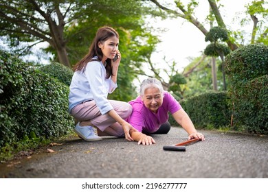 Asian Senior Woman Fell Down On Lying Floor Because Faint And Limb Weakness And Pain From Accident And Woman Came To Help Support And Call Emergency. Concept Of Old Elderly Insurance And Health Care