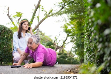 Asian Senior Woman Fell Down On Lying Floor Because Faint And Limb Weakness And Pain From Accident And Woman Came To Help Support And Call Emergency. Concept Of Old Elderly Insurance And Health Care