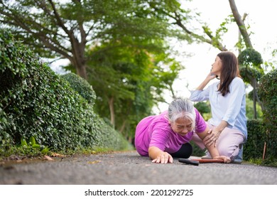 Asian Senior Woman Fell Down On Lying Floor Because Faint And Limb Weakness And Pain From Accident And Woman Came To Help Support And Call Emergency. Concept Of Old Elderly Insurance And Health Care