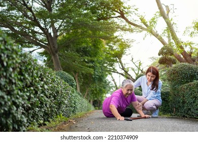 Asian Senior Woman Fell Down On Lying Floor Because Faint And Limb Weakness And Crying In Pain Form Accident And Her Daughter Came To Help Support. Concept Of Old Elderly Insurance And Health Care