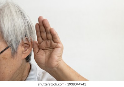 Asian senior woman having impaired hearing,deaf,ear disease,old elderly people trying to listening with hand over her ear,trouble hearing,chronic otitis,acute ear infections,problems of deafness