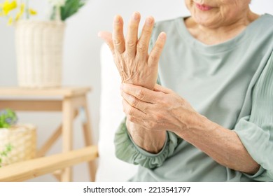 Asian senior woman having the joint pain at the living room