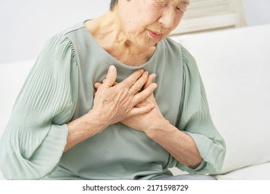 Asian senior woman having a palpitation of the heart at home - Shutterstock ID 2171598729