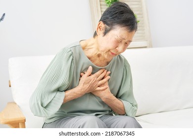 Asian senior woman  having a palpitation of the heart at home - Powered by Shutterstock