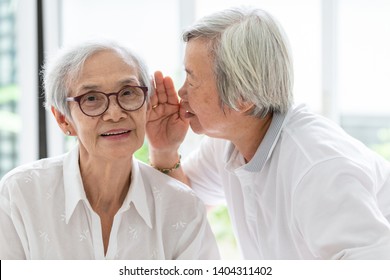 Asian Senior Woman Holding Hand Near Mouth Telling Funny,gossips On Ears To Friend,speaking In Elderly Woman Ear And Near Face,having Difficulty In Hearing,hard To Hear,hearing Impaired Old People