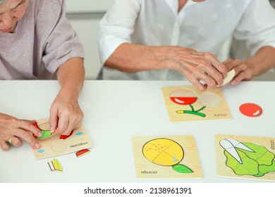 Asian Senior Woman Holding Jigsaw Puzzle Pieces,old Elderly Playing A  Jigsaw Puzzle Games With Her Friend,leisure Activities,development Of Brain,prevent Alzheimer's Disease And Dementia Problems