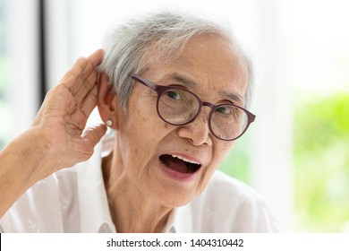 Asian Senior Woman Listening By Hand’s Up To The Ear,having Difficulty In Hearing,elderly Woman Hard To Hear,wear Glasses With Hearing Impairment,hearing Impaired Old People