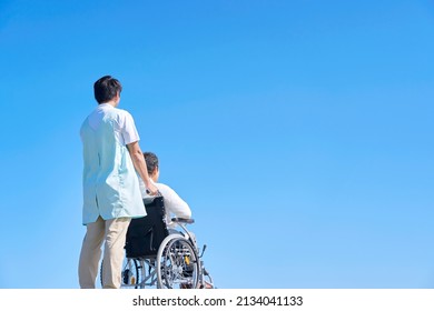 Asian Senior Woman On The Wheelchair And Asian Caregiver Outdoor