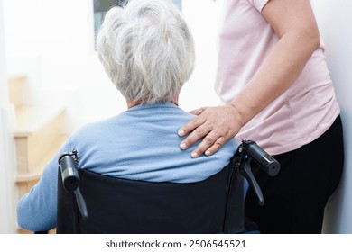 Asian senior woman on wheelchair with caregiver help support walking down the stairs prevent accident, slip and fall at home. - Powered by Shutterstock