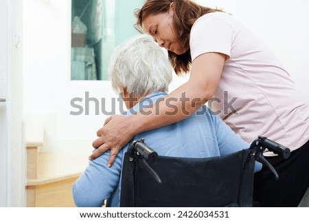 Asian senior woman on wheelchair with caregiver help support walking down the stairs prevent accident, slip and fall at home.