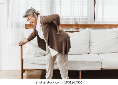 Asian senior woman pain from backache alone at home. Elderly woman pain and hurt from osteoporosis sickness or back injury. Old adult life insurance with health care and treatment concept - Shutterstock ID 1931267066