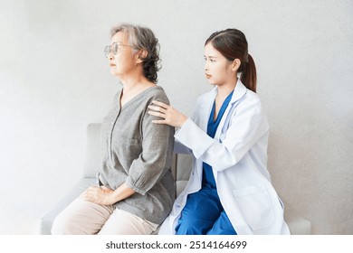 Asian senior woman patient during lower back exam by young asian woman physiotherapist in rehabilitation clinic - Powered by Shutterstock