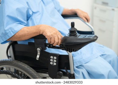 Asian senior woman patient on electric wheelchair with remote control at hospital, healthy strong medical. - Powered by Shutterstock