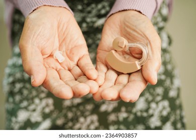 Asian senior woman patient using hearing aid in ear to reduce hearing loss problem. - Powered by Shutterstock