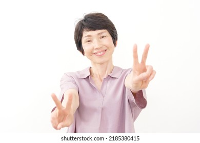 Asian Senior Woman Peace Sign Gesture In White Background 