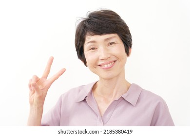 Asian Senior Woman Peace Sign Gesture In White Background 