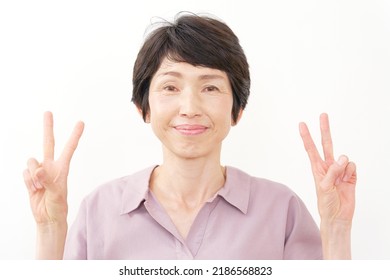 Asian Senior Woman Peace Sign Gesture In White Background