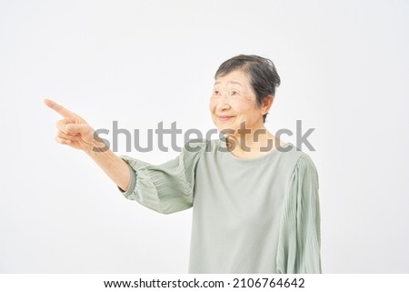 Asian senior woman pointing side in white background