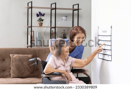 Asian senior woman read a calendar therapy exercises used by dementia patients with caregiver.