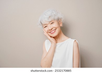 Asian senior woman smiling in the beige background